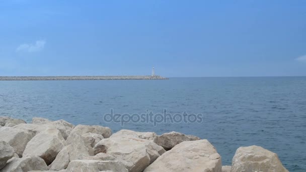 Faro en el arrecife y la playa rocosa — Vídeo de stock