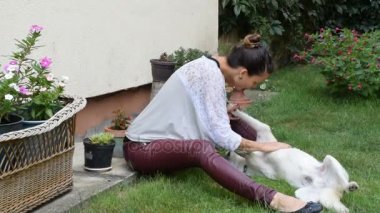 onun sırt ve kız, onu sarılma onun sahibi beyaz köpek yatıyor