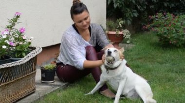 Kız kucaklamak köpeğini o içinde onun ağız bir tenis topu tutar süre