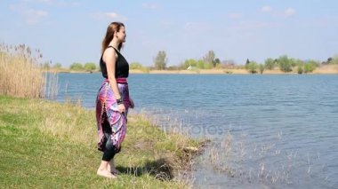 Kıyıda duran, doğa izliyor ve derin nefes genç kız