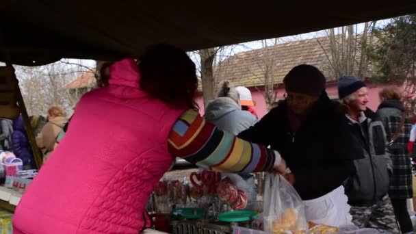 12 Mart 2017 bir durak ile renkli şekerler ve lolipop Belo Blato, Voyvodina, Sırbistan, fuarda, tatlılar satan bir kadın. — Stok video