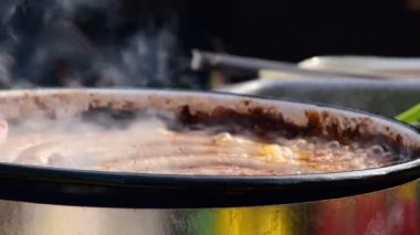 bir sosis büyük bir kızartma tavada yerleştirerek Belo Blato, Voyvodina, Sırbistan, 12 Mart 2017.