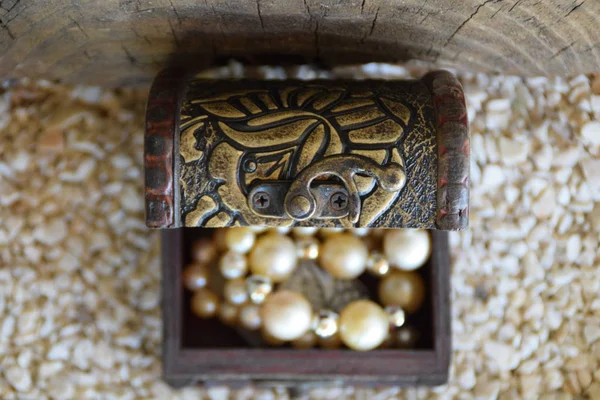 An old ornamental jewelry box and a white pearl necklace, a suitcase with a treasure from above — Stock Photo, Image