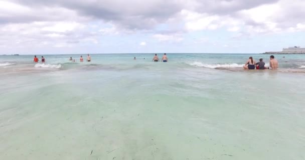 Turister som njuter av på stranden i grunt — Stockvideo