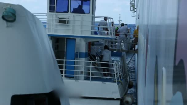 La gente está cargando suministros desde el crucero en el barco más pequeño — Vídeos de Stock