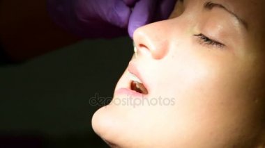 Diş hekimi hastanın ağzına kabloyu kesmek için maşa kullanır