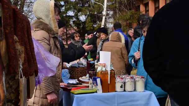 Mujer que vende comida casera: jugo de tomate, mermelada, relojes de madera, Belo Blato, Vojvodina, Serbia, 12 de marzo de 2017 . — Vídeos de Stock