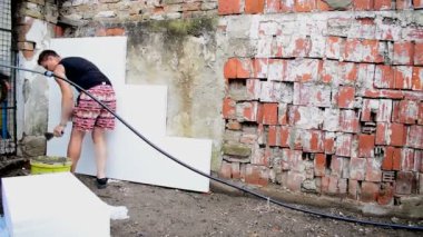 Arka duvarda onarım işleri yapan genç erkek