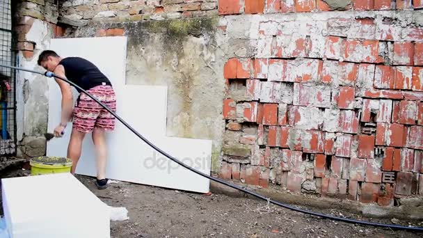 Jonge man doen reparatie werkt op de muur in de achtertuin — Stockvideo