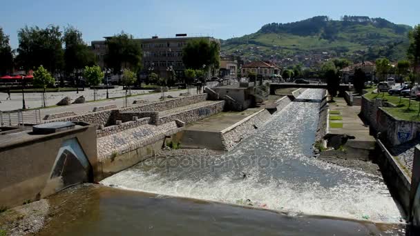 Fiume scorre nella piccola città vicino alla collina — Video Stock