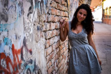 Güzel kız bir rustik duvar poz