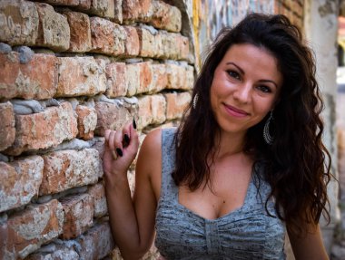 Güzel kız bir rustik duvar poz