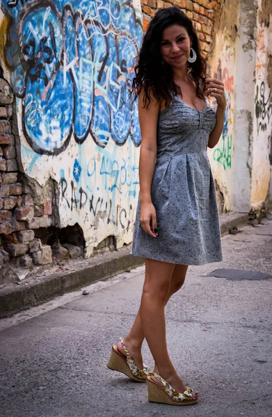 Güzel bir kız rustik duvar poz ve grafiti ile boyalı