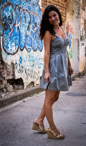 Güzel bir kız rustik duvar poz ve grafiti ile boyalı