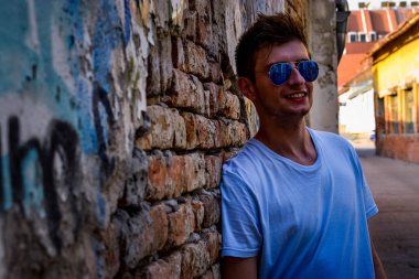 Genç adam bir rustik duvar poz