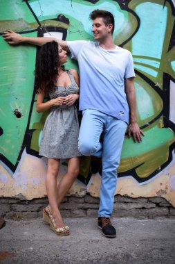 Duvarın önünde kadın ve genç adam