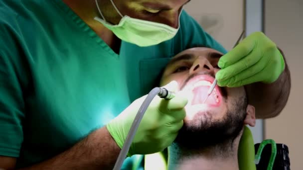 A young man removes caries of teeth at the dentist — Stock Video