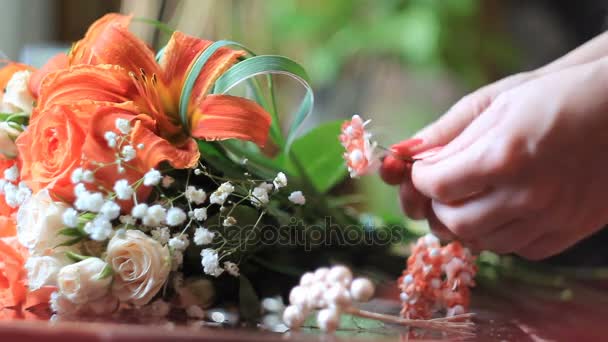 Жіночі руки роблять красивий весільний букет в квітковому магазині — стокове відео