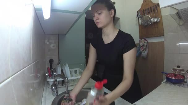 Une jeune femme européenne lave la vaisselle dans la cuisine — Video