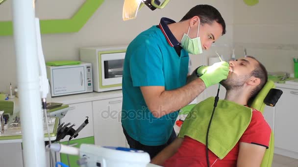 Zahnlaser im Mund des Patienten, junger Mann — Stockvideo