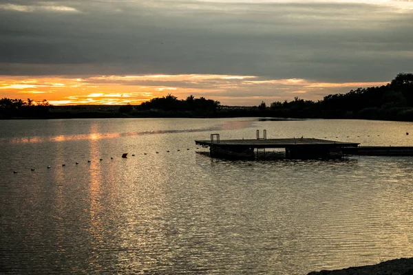 Friedlicher Sonnenuntergang und Holzsteg am See — Stockfoto
