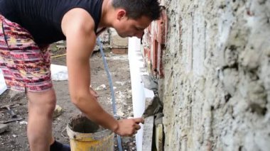 Köpük yalıtım, onarım yapan genç erkek arka duvardaki çalışır