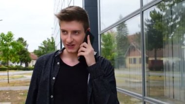 genç bir adam tarafından bir iş cam bina geçen süre telefonda konuşurken siyah