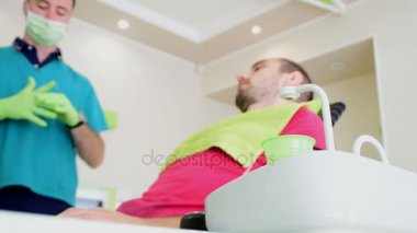 Onun teeths dişçisi giderir iken diş sandalyede oturan genç yakışıklı adam