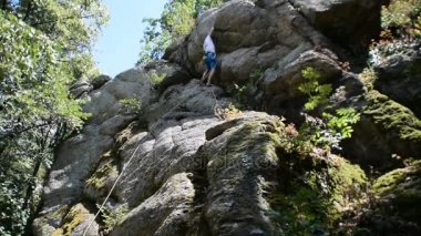 Dağcılık donanımları ile Rock genç bir adam tırmanıyor