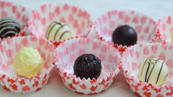 Bolas de chocolate, mano de mujer tomando dulces, decoración con corazones — Vídeos de Stock