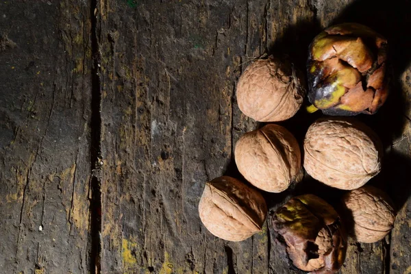 Ořechy na tmavém dřevěném stole — Stock fotografie