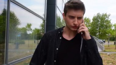 genç bir adam tarafından bir iş cam bina geçen süre telefonda konuşurken siyah