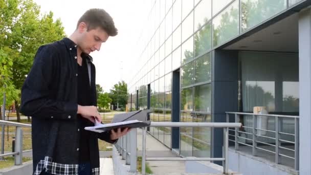 Préoccupation jeune homme regardant des notes dans ses mains — Video