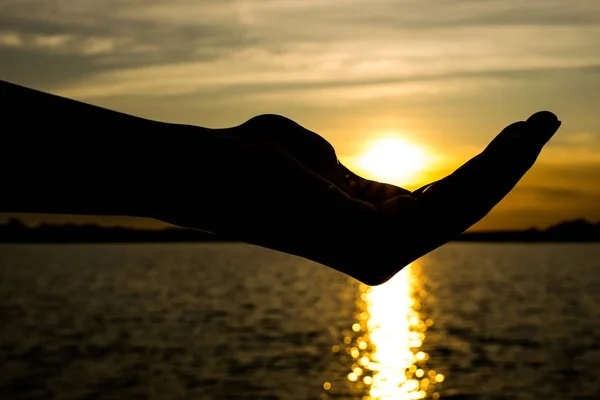 El sol sobre la silueta de la mano femenina — Foto de Stock