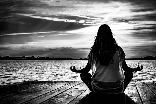 Młodych kobiet w pozycji jogi medytacji na ponton drewniane na jeziorze — Zdjęcie stockowe