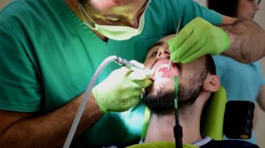 Yakışıklı delikanlı iken onun teeths dişçisi giderir diş iskemlede çürük diş temizliği
