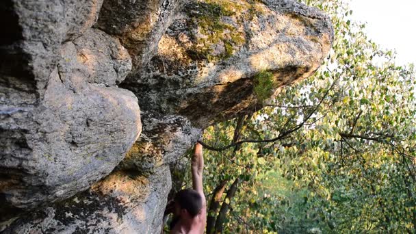 一个年轻的男人爬到岩石没有攀岩设备，自由攀岩 — 图库视频影像