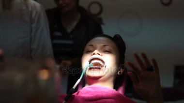 diş hekimi diş telleri genç bir kadın dişlerde koyuyor