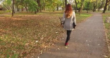 o bankta oturdu sonra kürsüye parkta yürüyüş bir dizüstü bilgisayar ile bir kız laptopunu açtı ve çalışmaya başladı