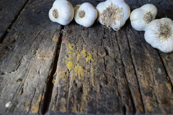 Sarımsak koyu ahşap bir masa üzerinde başkanları — Stok fotoğraf