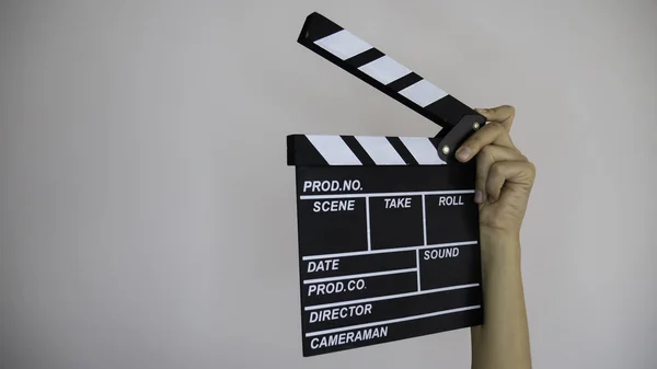 Close up female holding in hand classic director clear empty black film making clapperboard isolated on light gray background. Cinematography production concept. Copy space for advertising. Negative space.