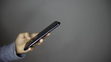 Sol kadın elinin boş ekran akıllı telefonunu tutarken yan görüntüsü. Boşluk yok. Metin için alanı kopyala.