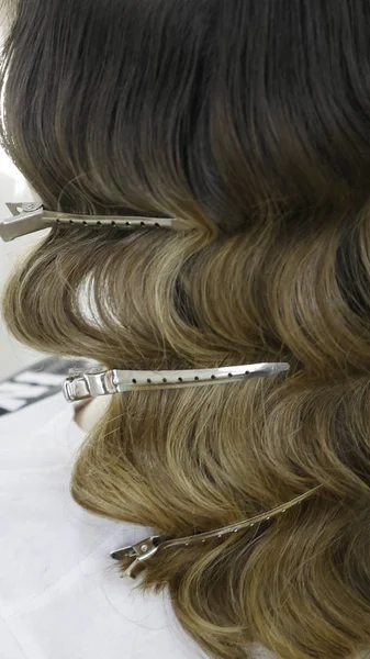 Silver hairdressers clips in wavy hair - close up