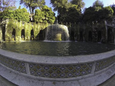 Oval Çeşme (Fontana dell 'Ovato) güneşli bir günde İtalya' nın Tivoli kentindeki Villa D 'Este' nin güzel bahçelerinde. Oval Çeşme ya da Fontana dell 'Ovato' nun yumurta şekilli havuzu ve Sibyl Albunensa heykeli gibi büyük taş havzaları.. 