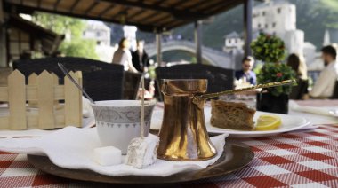 Bosna-Hersek 'in arka planında Mostar Eski Köprüsü manzaralı geleneksel Bosna kahvesi. Geleneksel Türk kahvesi ve Türk lokumu. 