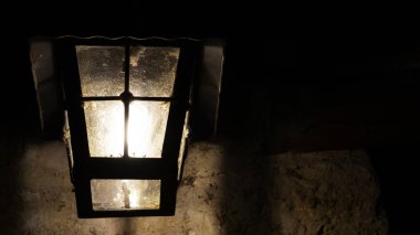 Gece eski bir duvarda dekoratif lamba.