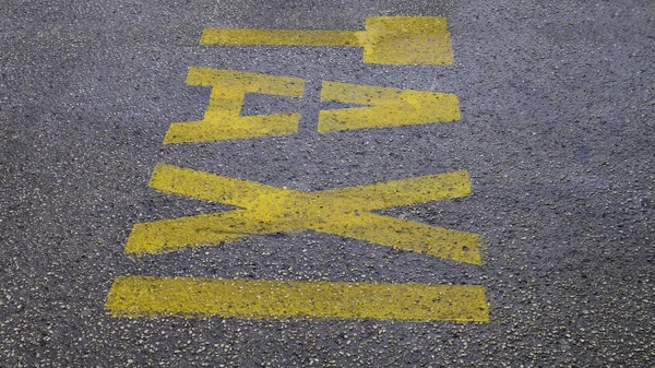 人行道上的黄色字 出租车 街道的地板上标有出租车标志 城市街道上出租车处路标站黄色符号字母 — 图库照片