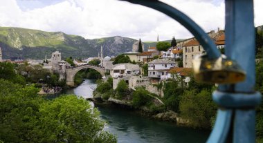 Eski Köprü ve Mostar şehrinin bir Harbor Köprüsü (Mujage Komadine Köprüsü) çiti üzerinden görüntüsü. Mostar, Bosna-Hersek.