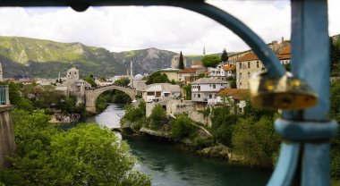 Old Bridge and the city of Mostar through the fence of a Harbor Bridge. Mostar, Bosnia and Herzegovina.