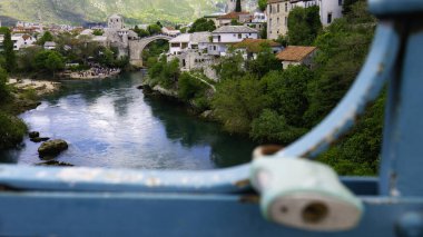 Old Bridge and the city of Mostar through the fence of a Harbor Bridge. Mostar, Bosnia and Herzegovina.